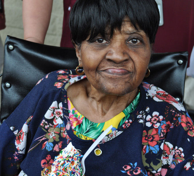 Peace Care resident sitting in a wheelchair and smiling.
